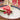 Slice of watermelon and cherries on a plate with a wooden background