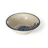 Ceramic bowl with blue rim and decorative pattern on a white background