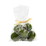 A clear plastic bag tied with a yellow ribbon, containing green eggs designed as spring decor.