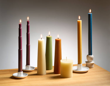 Various Greentree brand candles in holders, lit