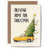 Card with a yellow car carrying a Christmas tree and text 'Driving Home for Christmas' on a white background.
