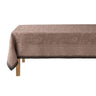 Brown patterned tablecloth on a wooden table with a white background