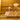 Dining room with a table set for a meal against a mustard yellow wall.