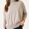 Woman wearing a beige sweater on a white background