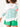 MERSEA’s Amour striped sweater with heart appliqué on elbow. Sweater is white with narrow Kelly green stripes. The top stripe is pink, and the heart appliqués are also pink.