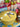 Yellow pot with a decorative tag on a colorful tablecloth