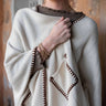 Mersea Whipstitch travel wrap in cream with contrasting bronze stitching. One size, features two front pockets.