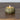 Small pumpkin-shaped candle with a lit wick on a wooden surface